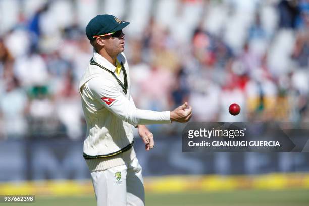 Australian Vice Captain David Warner passes the ball during the fourth day of the third Test cricket match between South Africa and Australia at...