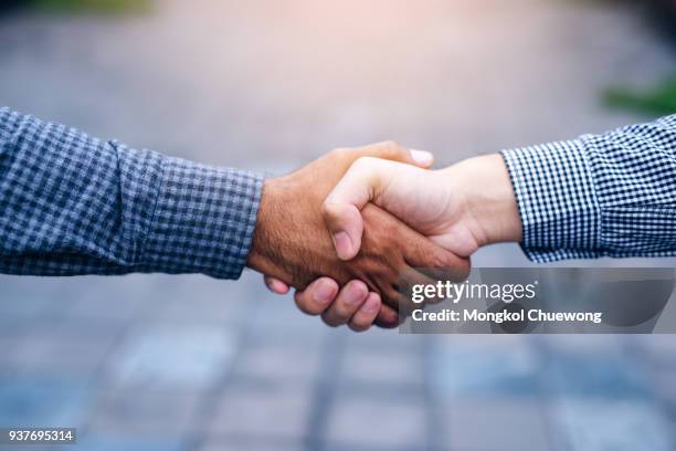 scene of businessman handshake in outdoors - seriös stock-fotos und bilder