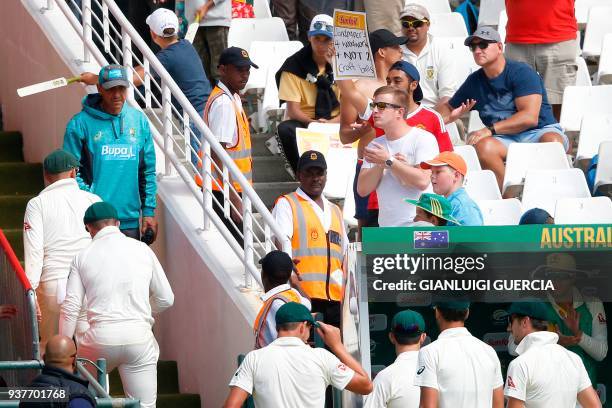 South African supporter holds a placard reading "Sandpaper 4 woodwork + not 2 craft balls", in reference to the ball tampeting scandal, as the...