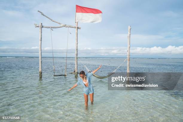 meisje lopen op het strand, swing door de zee, indonesië - gili trawangan stockfoto's en -beelden