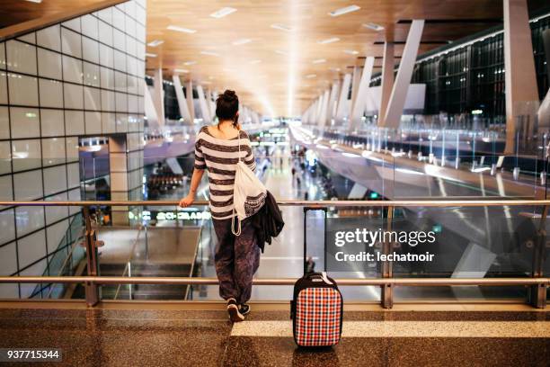 giovane donna con una valigia in viaggio da sola sull'aeroporto del qatar - doha foto e immagini stock