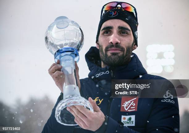 France's Martin Fourcade poses with the crystal globe trophy following the mass start event at the IBU Biathlon World Cup Final in Tyumen, on March...