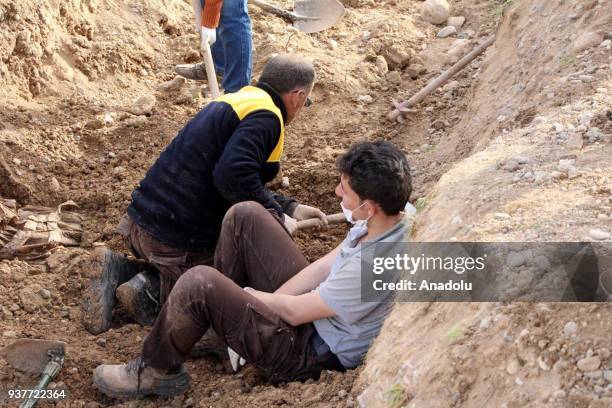 Members of White Helmet dig the area after Free Syrian Army fighters found mass grave in recently liberated Kucuk Meydan village during search...