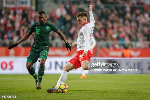 Jakub Swierczok of Poland shoots past Abdullahi Shehu of Nigeria during the international friendly match between Poland and Nigeria at the Municipal...