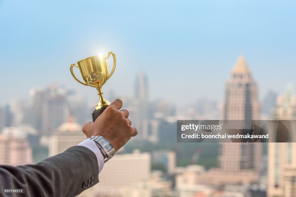Businessman celebrating with trophy