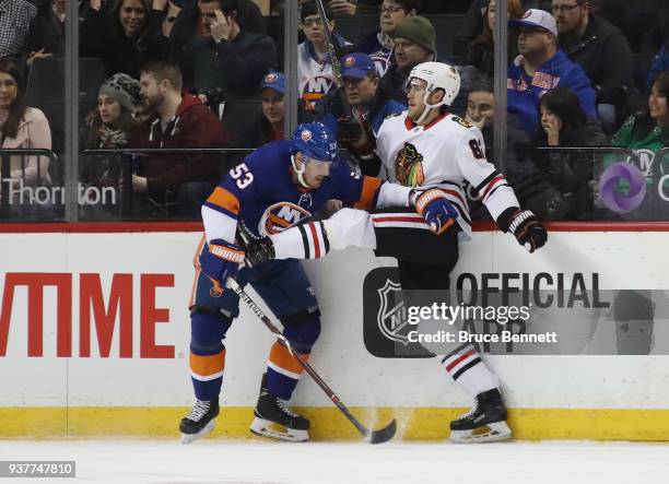 Jordan Oesterle of the Chicago Blackhawks skates against Casey Cizikas of the New York Islanders at the Barclays Center on March 24, 2018 in the...
