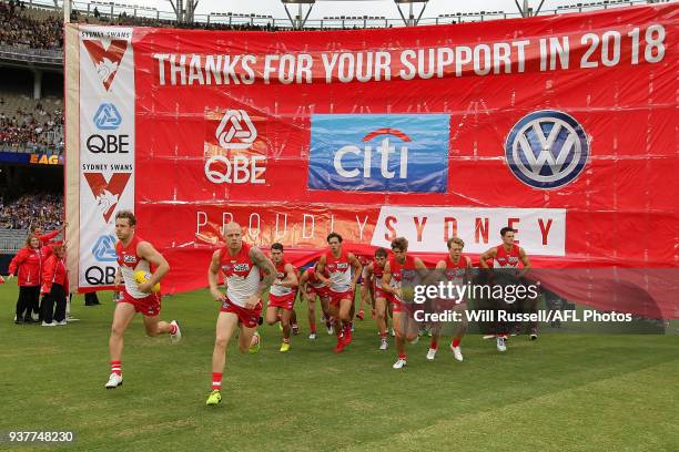 The Swans run through the banner during the round one AFL match between the West Coast Eagles and the Sydney Swans at Optus Stadium on March 25, 2018...