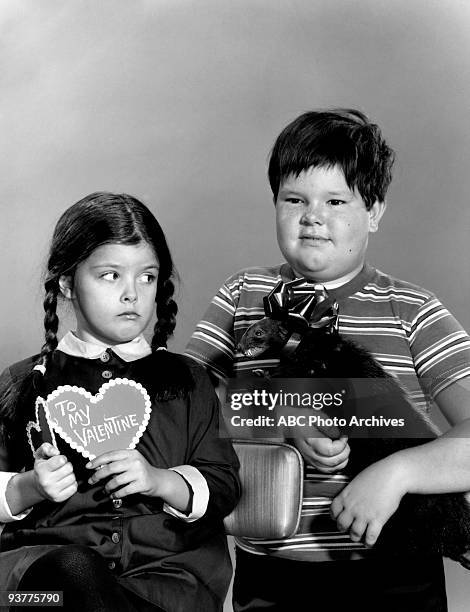 The Addams Family "Adams Family Gallery" Season One, Wednesday poses holding a valentine with her Brother Pugsley holding a Taxidermied animal.,