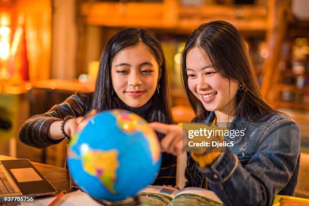 twee gelukkige jonge aziatische vrouwen verkennen van de hele wereld. - europe asian culture stockfoto's en -beelden