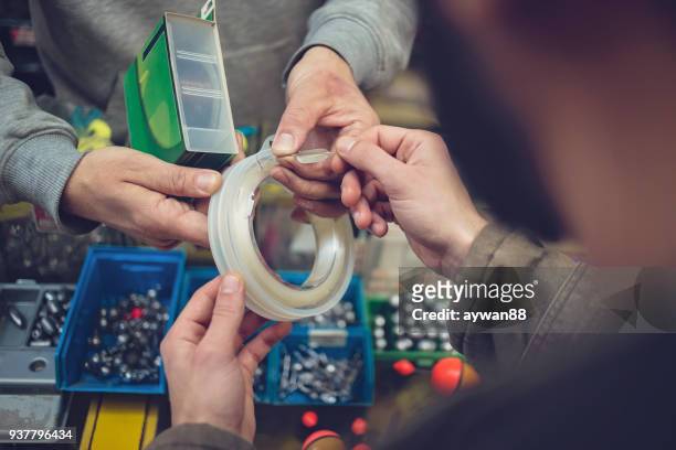man buying fishing bait in a store - barbed hook stock pictures, royalty-free photos & images