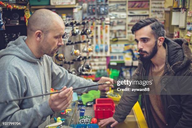 man buying new fishing rod - barbed hook stock pictures, royalty-free photos & images