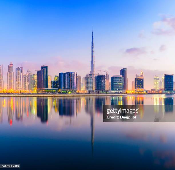 die innenstadt von dubai skyline bei sonnenuntergang - burj khalifa stock-fotos und bilder
