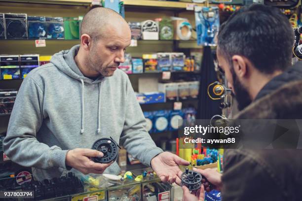 man buying fishing rod - barbed hook stock pictures, royalty-free photos & images