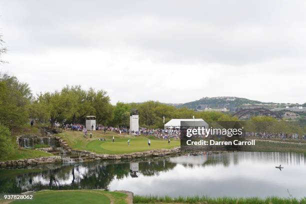 Kevin Kisner of the United States putts on the 11th green as Alexander Noren of Sweden looks on during the semifinal round of the World Golf...