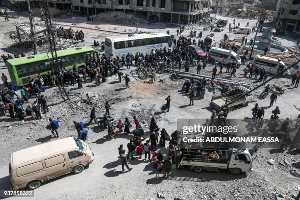 Syrian civilians and rebel fighters prepare to embark aboard buses during the evacuation from the town of Arbin in the Eastern Ghouta region on the...