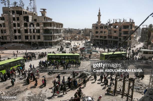 Syrian civilians and rebel fighters prepare to embark aboard buses during the evacuation from the town of Arbin in the Eastern Ghouta region on the...