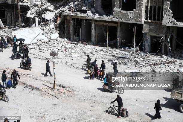 Picture taken on March 25, 2018 shows people preparing to evacuate from the town of Arbin in the Eastern Ghouta region on the outskirts of the...