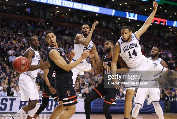 Mikal Bridges and Omari Spellman of the Villanova Wildcats knock the ball away from Niem Stevenson of the Texas Tech Red Raiders during the second...