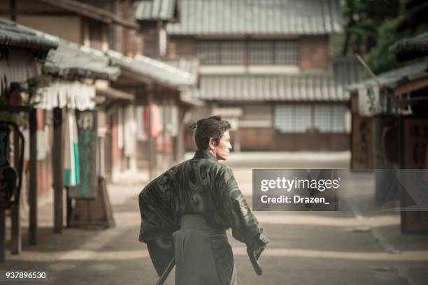 samurai in traditional japanese village from 19th century - katana stock pictures, royalty-free photos & images