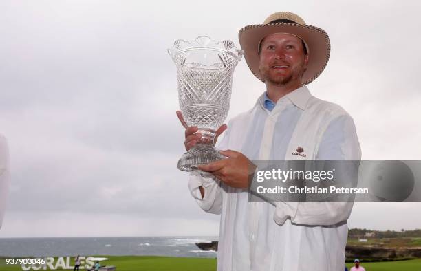 Brice Garnett poses wiht the trophy after putting in to win on the 18th green during the final round of the Corales Puntacana Resort & Club...