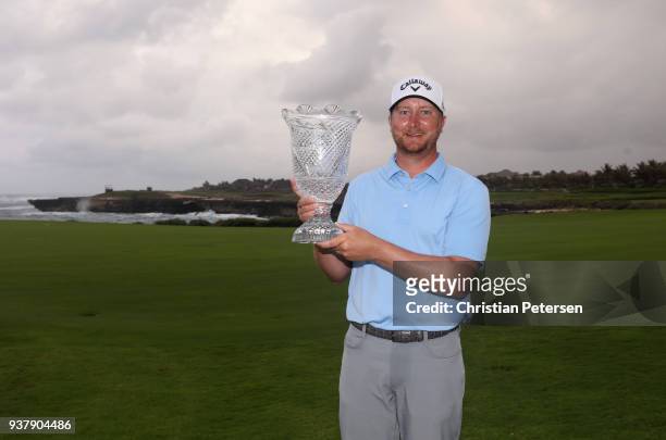 Brice Garnett poses with the trophy after putting in to win on the 18th green during the final round of the Corales Puntacana Resort & Club...