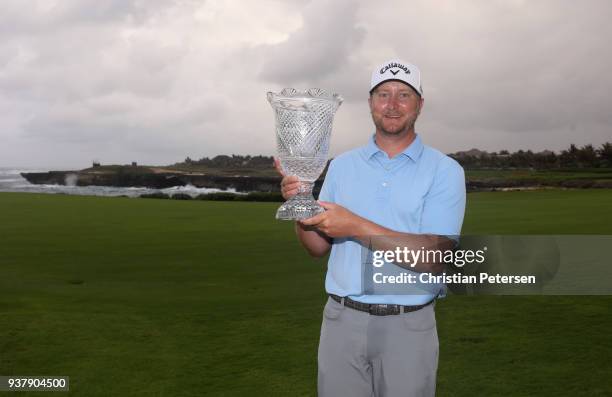 Brice Garnett poses with the trophy after putting in to win on the 18th green during the final round of the Corales Puntacana Resort & Club...