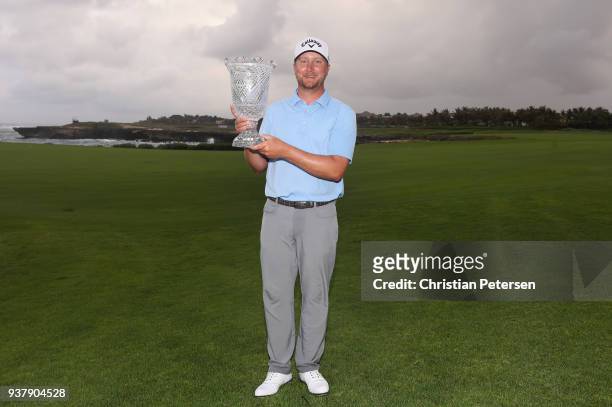Brice Garnett poses with the trophy after putting in to win on the 18th green during the final round of the Corales Puntacana Resort & Club...
