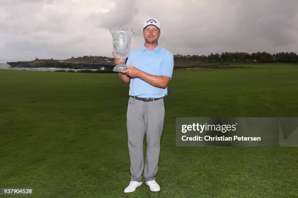 Brice Garnett poses with the trophy after putting in to win on the 18th green during the final round of the Corales Puntacana Resort & Club...