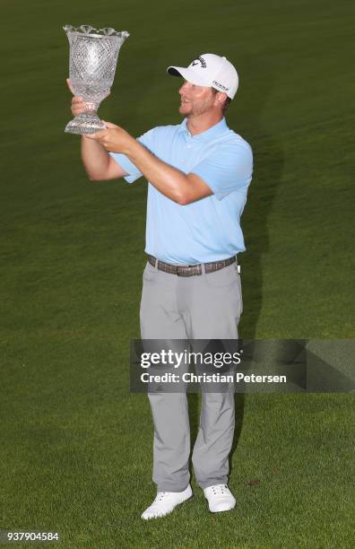 Brice Garnett poses with the trophy after putting in to win on the 18th green during the final round of the Corales Puntacana Resort & Club...