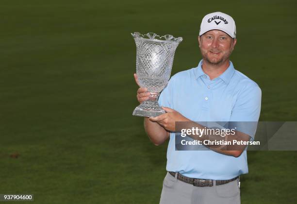 Brice Garnett poses with the trophy after putting in to win on the 18th green during the final round of the Corales Puntacana Resort & Club...