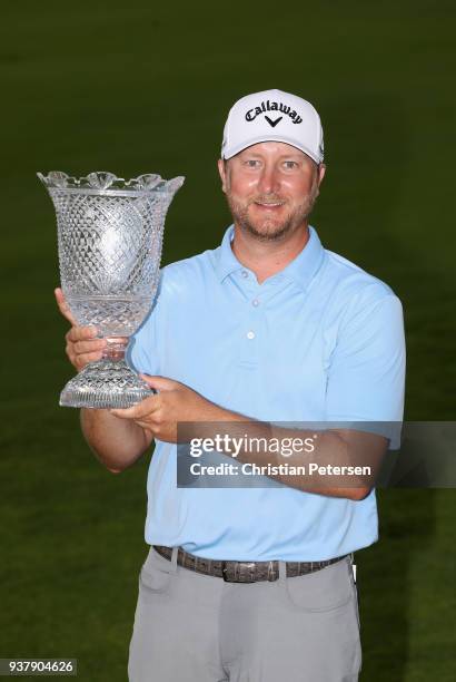 Brice Garnett poses with the trophy after putting in to win on the 18th green during the final round of the Corales Puntacana Resort & Club...