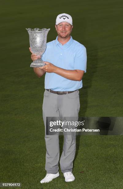 Brice Garnett poses with the trophy after putting in to win on the 18th green during the final round of the Corales Puntacana Resort & Club...