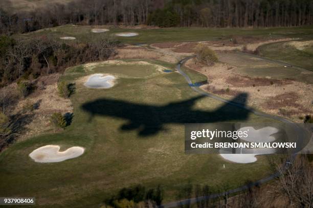 Air Force One's shadow is seen over Andrews Air Force Base's golf course while US President Donald Trump travels back to Washington from Mar-a-Lago...