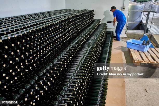 wine bottles being stacked at cooperativa vinícola são joão, southern brazil. - cooperativa stock pictures, royalty-free photos & images