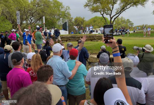 Fans watch Kevin Kisner hitting a tee shot on the 12th hole during the championship match at the World Golf Championships-Dell Technologies Match...