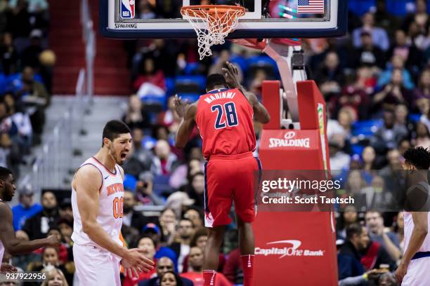 Enes Kanter of the New York Knicks reacts after Ian Mahinmi of the Washington Wizards dunks during the first half at Capital One Arena on March 25,...