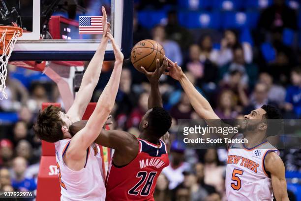Ian Mahinmi of the Washington Wizards goes to the basket against Luke Kornet and Courtney Lee of the New York Knicks during the first half at Capital...