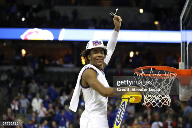 Devonte' Graham of the Kansas Jayhawks celebrates cutting down the net after defeating the Duke Blue Devils with a score of 81 to 85 in the 2018 NCAA...