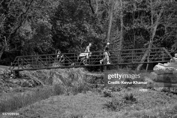 Bubba Watson and his caddie Ted Scott walk across the bridge to the fourth hole green during the championship match at the World Golf...