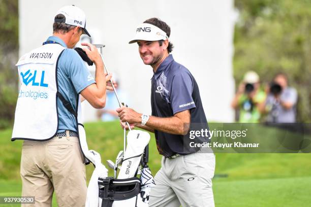 Bubba Watson laughs with his caddie Ted Scott after his chip shot to the 12th hole green during the championship match at the World Golf...