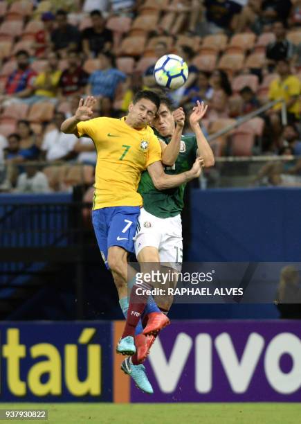 Brazil's forward Mauro Junior jumps for the ball with Mexico's defender Edgar Lopez during the international friendly Under-20 football match in...