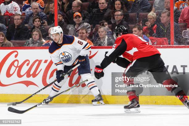 Ty Rattie of the Edmonton Oilers looks to make a pass against Cody Ceci of the Ottawa Senators at Canadian Tire Centre on March 22, 2018 in Ottawa,...