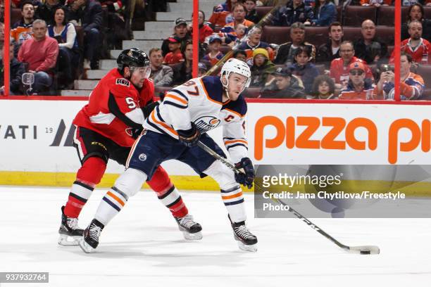 Connor McDavid of the Edmonton Oilers skates with the puck against Cody Ceci of the Ottawa Senators at Canadian Tire Centre on March 22, 2018 in...