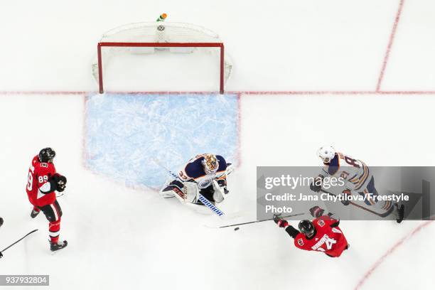 Cam Talbot of the Edmonton Oilers makes a save against Alexandre Burrows of the Ottawa Senators as Christian Wolanin of the Ottawa Senators and...