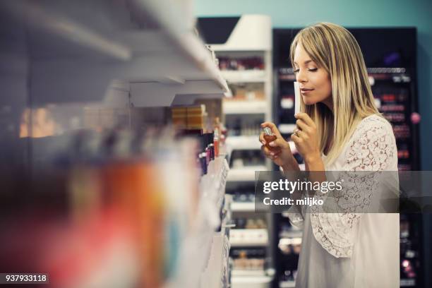 joven mujer de compras en cosmética y maquillaje - perfumería fotografías e imágenes de stock