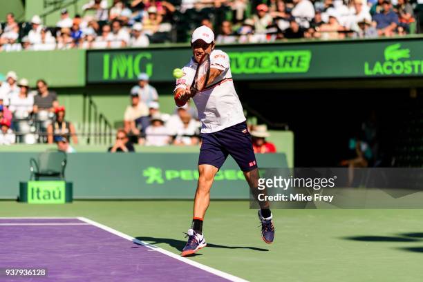 Kei Nishikori of Japan hits a backhand volley to Juan Martin Del Potro of Argentina during Day 7 of the Miami Open Presented by Itau at Crandon Park...