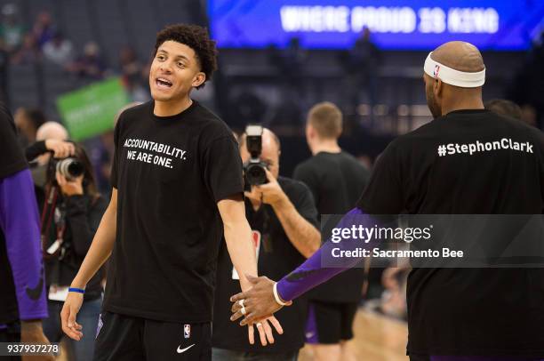 Sacramento Kings forward Justin Jackson slaps hands with Sacramento Kings guard Vince Carter as they wear T-shirts bearing the name of Stephon Clark...