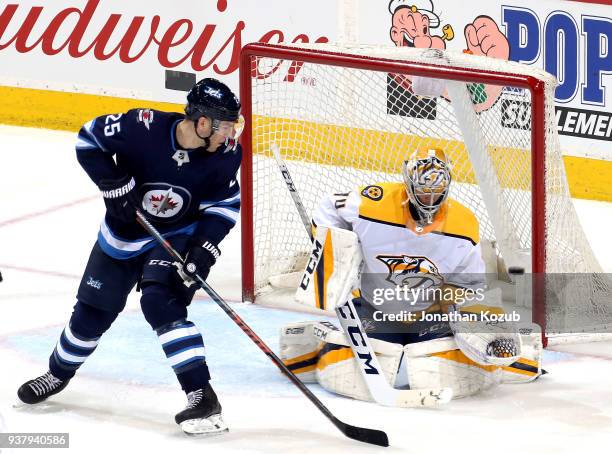 Paul Stastny of the Winnipeg Jets watches as a shot by teammate Dustin Byfuglien gets by goaltender Juuse Saros of the Nashville Predators for a...