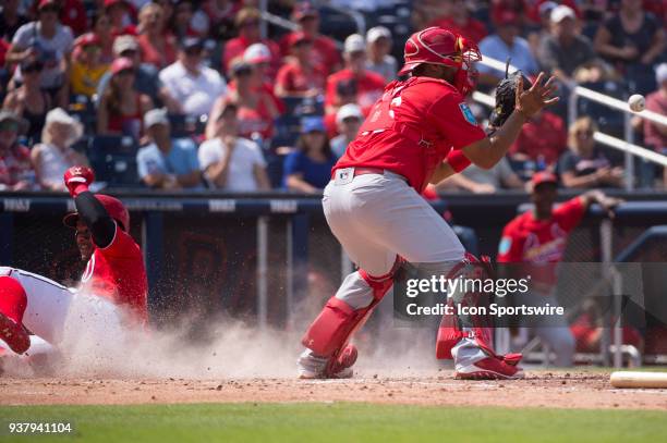 Washington Nationals Infielder Wilmer Difo safely slides across home plate to score a run while St. Louis Cardinals Non-Roster Invitee Catcher...