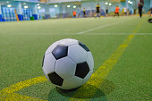 Soccer ball on a corner kick line on an artificial green grass